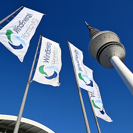 WindEnergy Hamburg flags against a blue sky.