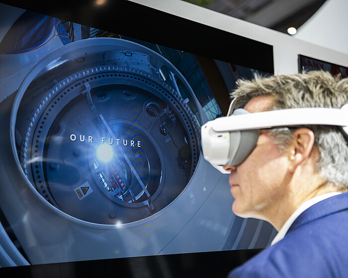 Trade fair visitor with VR headset in front of a digital visualization.