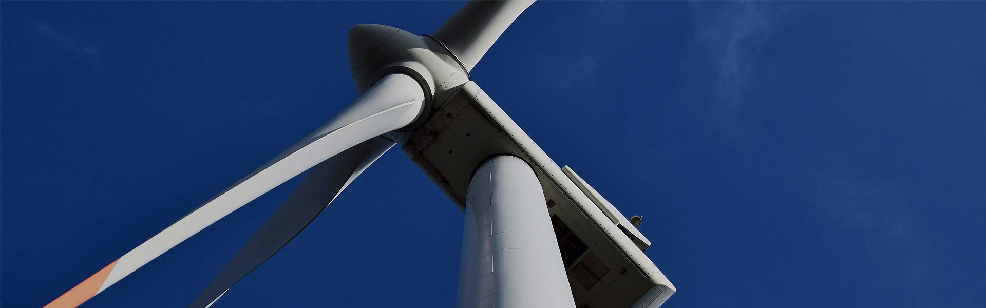 Wind turbine from below against a blue sky