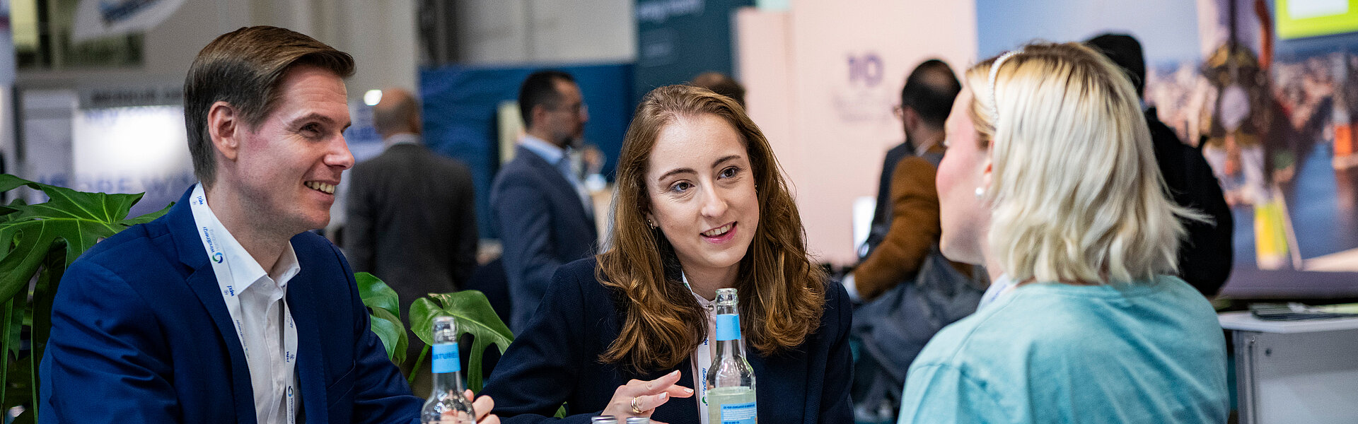Three people have a lively chat over a drink at WindEnergy Hamburg.