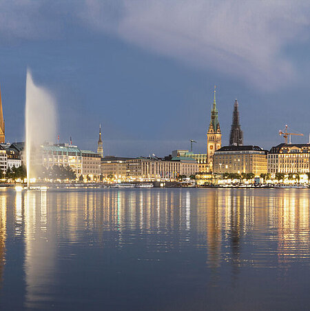 Blick auf die Hamburger Binnenalster mit Alsterfontäne am Abend 