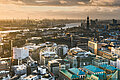 Key visual of the RECHARGE WindPower Summit. View of Hamburg with St. Michael's Church, the Elbphilharmonie, the Port of Hamburg, and City Hall. Wind turbines can be seen in the background.