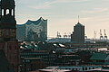 Key visual of the RECHARGE Wind Power Summit. View of the main church St. Michaelis, the Elbphilharmonie concert hall and Hamburg harbour. Wind turbines can be seen in the background.